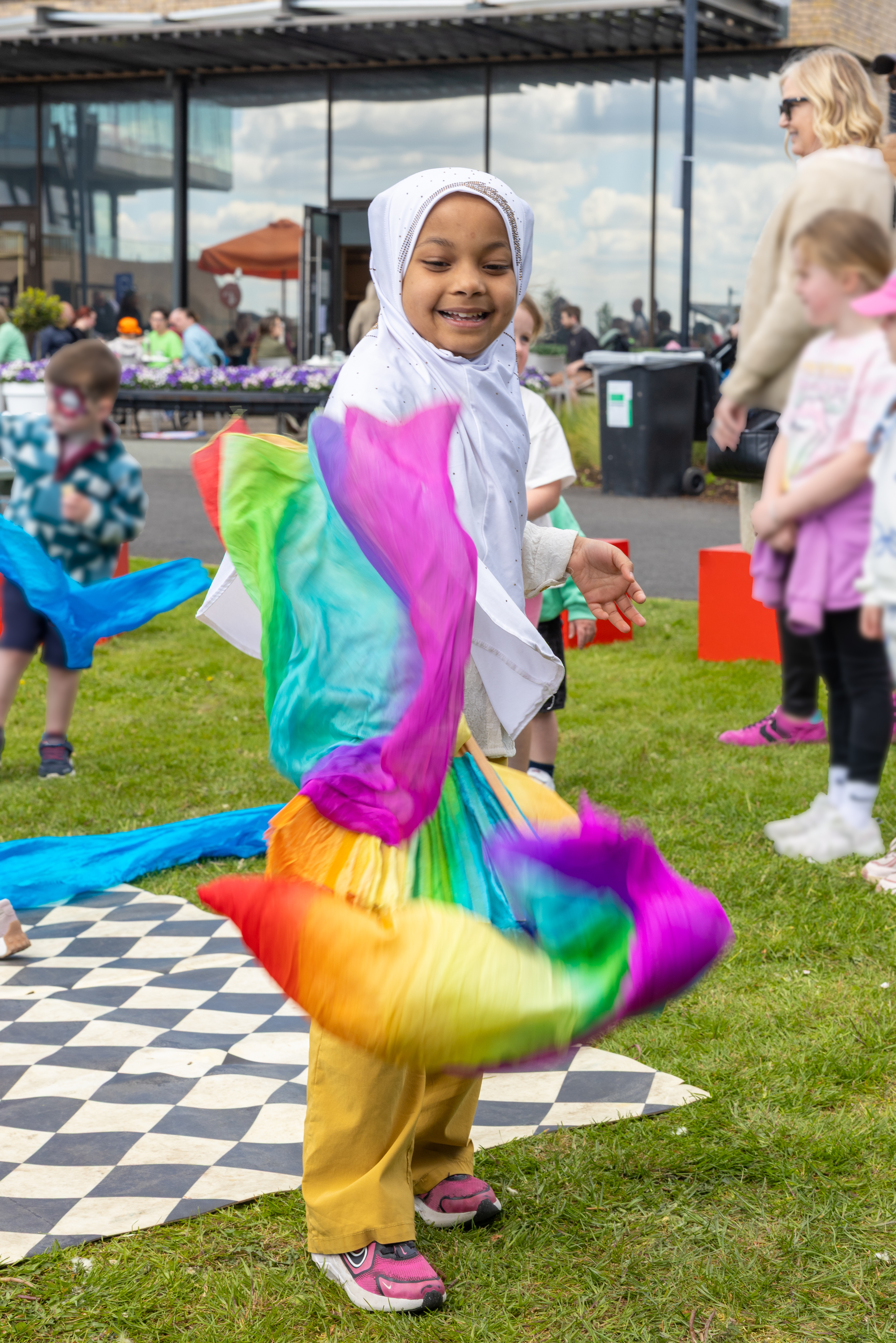 Child playing with rainbow ribbon. 